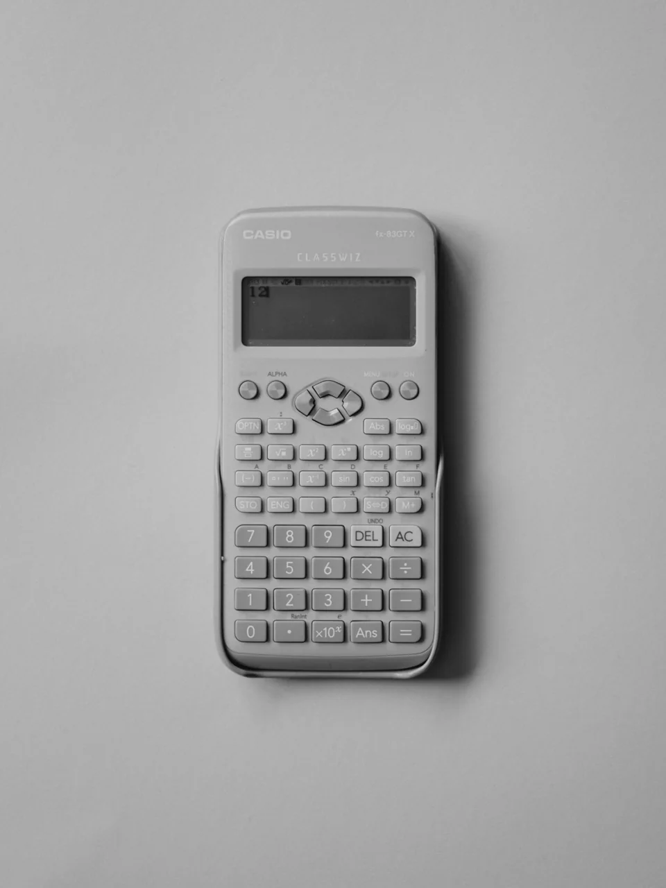 A white calculator on a plain gray background